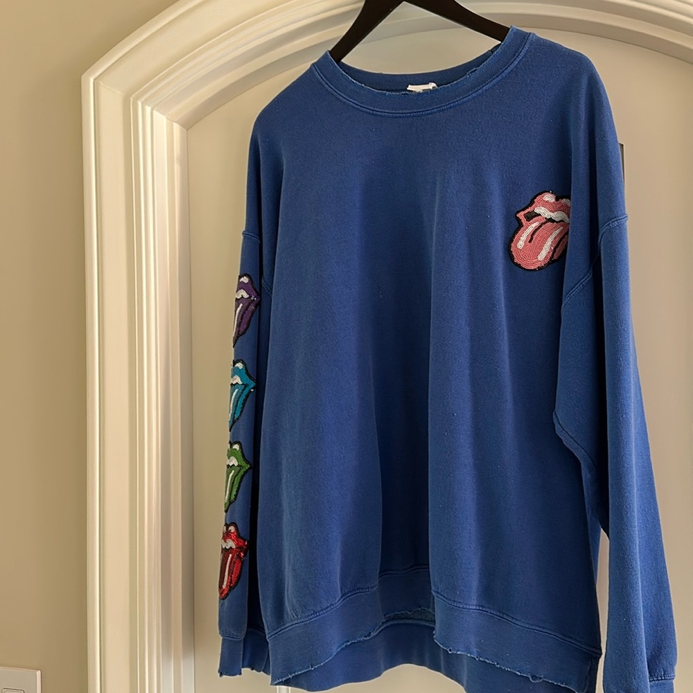 Blue sweatshirt with colorful tongues.